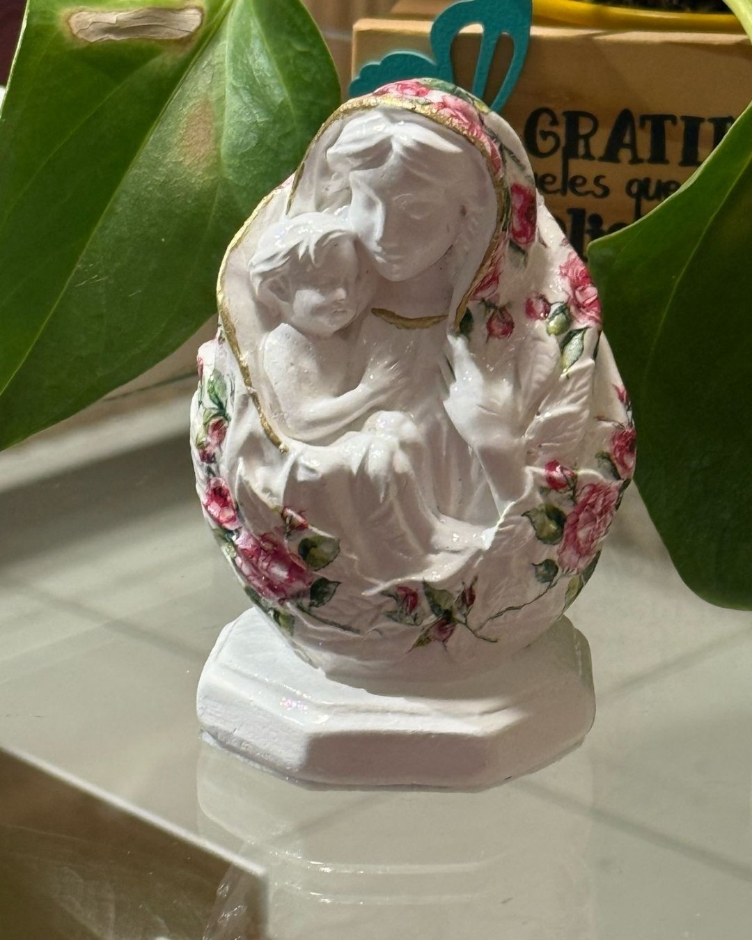 Estátua de Nossa Senhora com o Menino Jesus. Peça decorativa em resina com detalhes florais. Perfeita para expressar sua fé em casa.